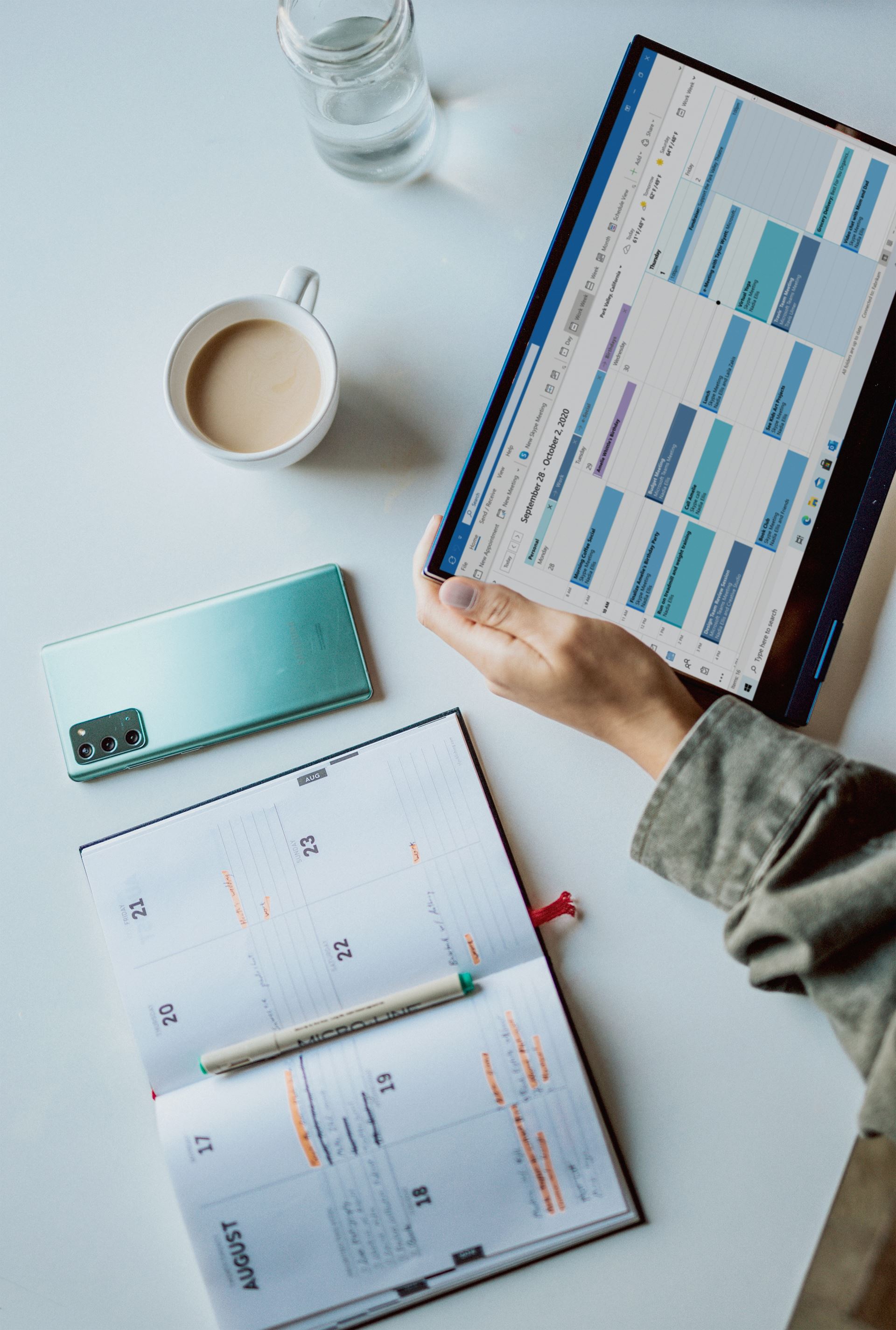 A person holding an iPad with a calendar app open